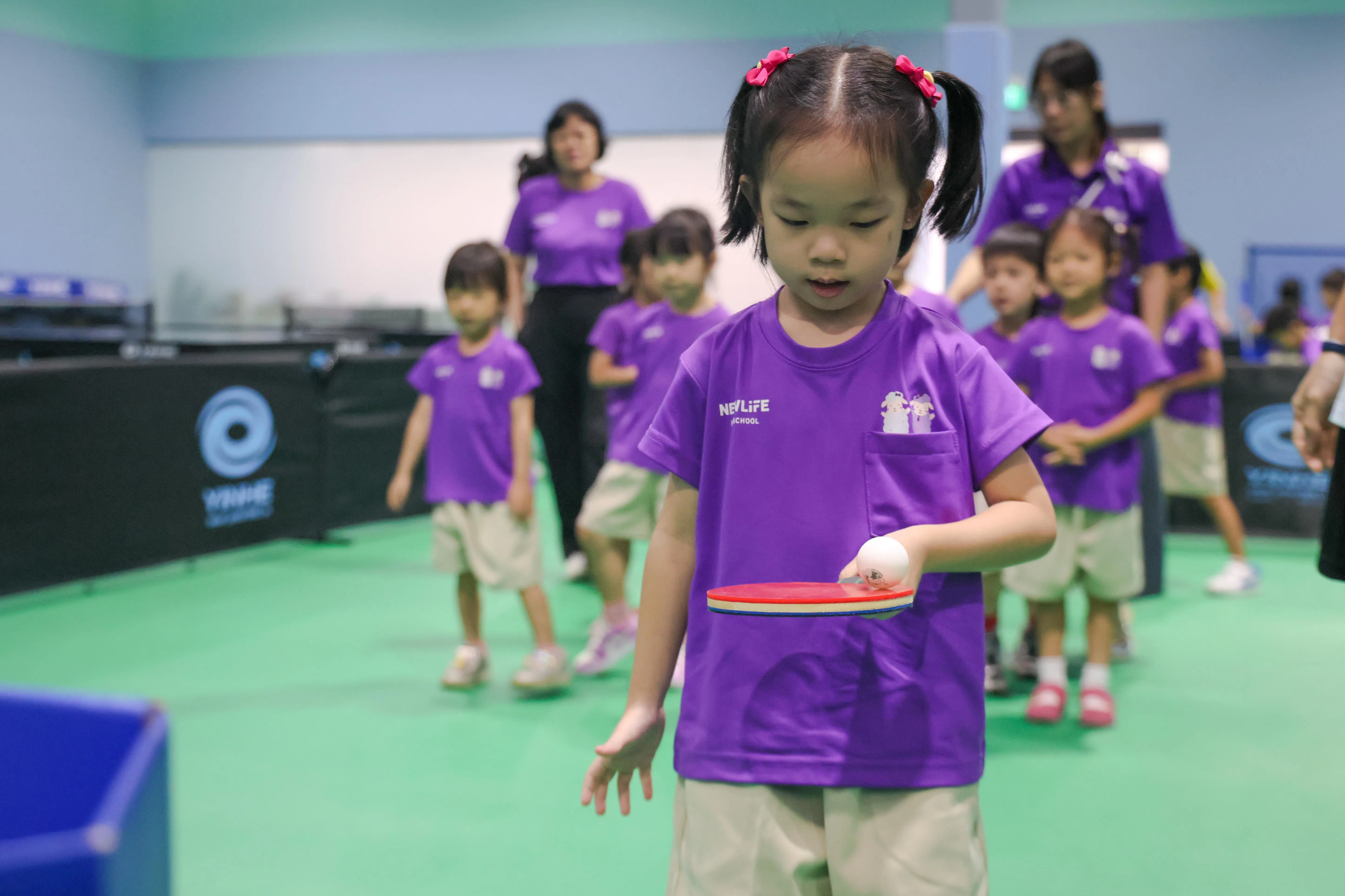 学院针对年幼孩童制定了“端球往返接力”等专属的训练计划，让孩童感受乒乓球的乐趣。（张俊杰摄）