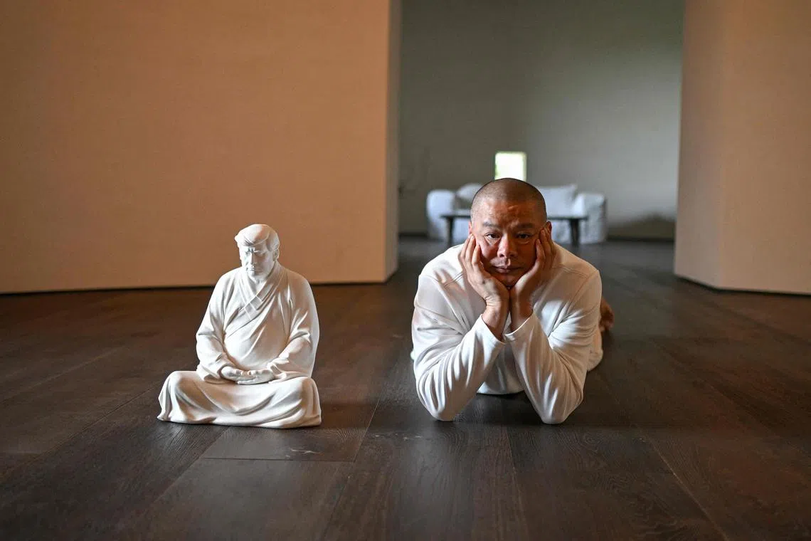 中国雕塑家洪金世（右）在厦门的个人工作室与特朗普陶瓷佛像雕塑合影。图摄于去年12月9日。（法新社）