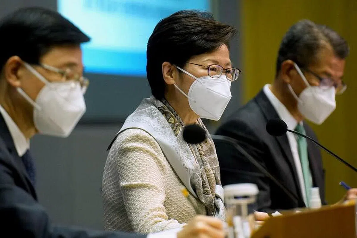 香港特首林郑（中）本周一在记者会上宣布暂缓全民检测计划。（路透社）