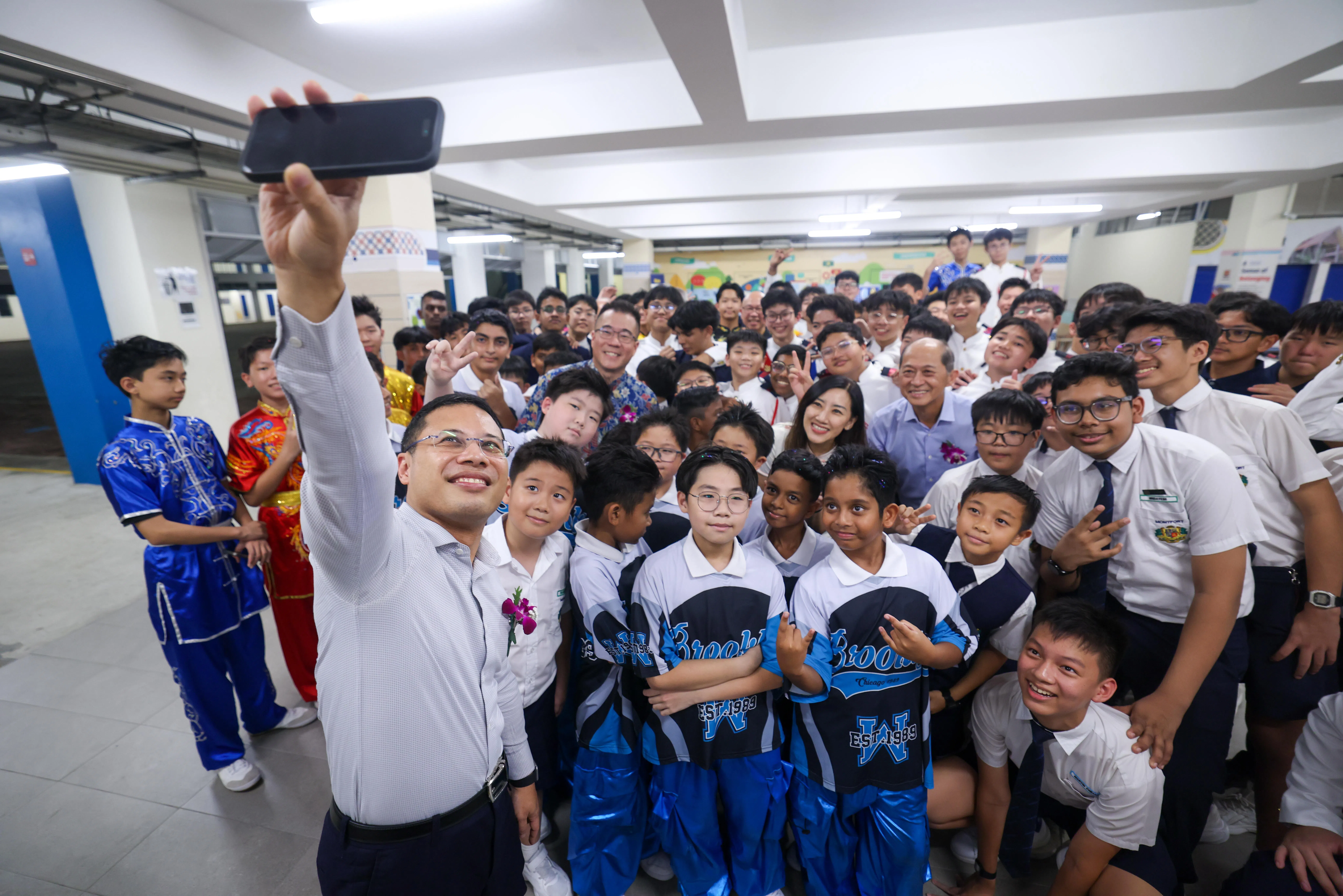 教育部长李智陞星期五（7月24日）以主宾身份出席蒙福中小学110周年校庆晚宴时，与在场师生自拍合照。（白艳琳摄）