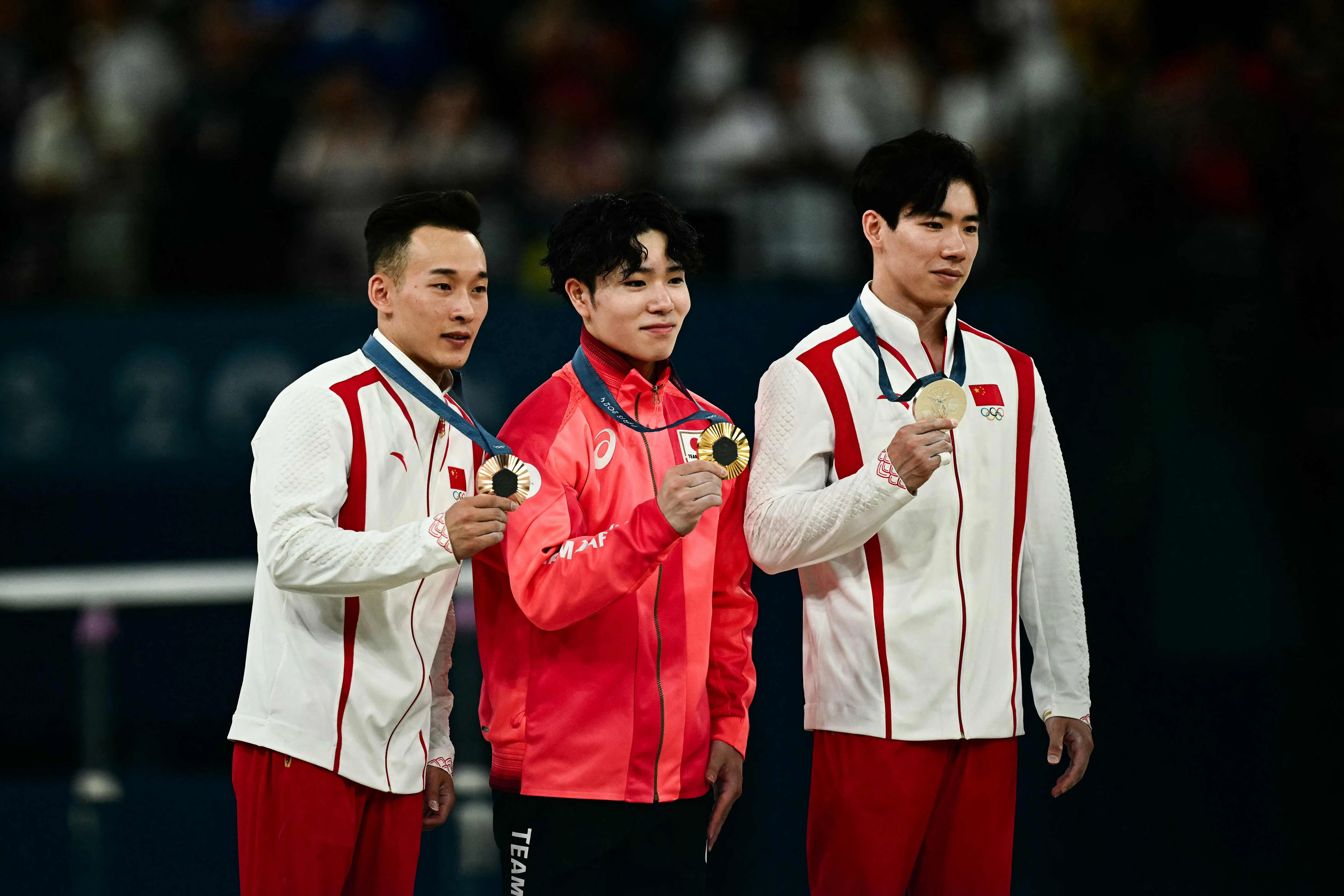 日本在男子团体赛和全能赛都压倒中国夺冠，中为夺冠黑马冈慎之助。张博恒（右）和肖若腾分别为中国得到银牌和铜牌。（法新社）