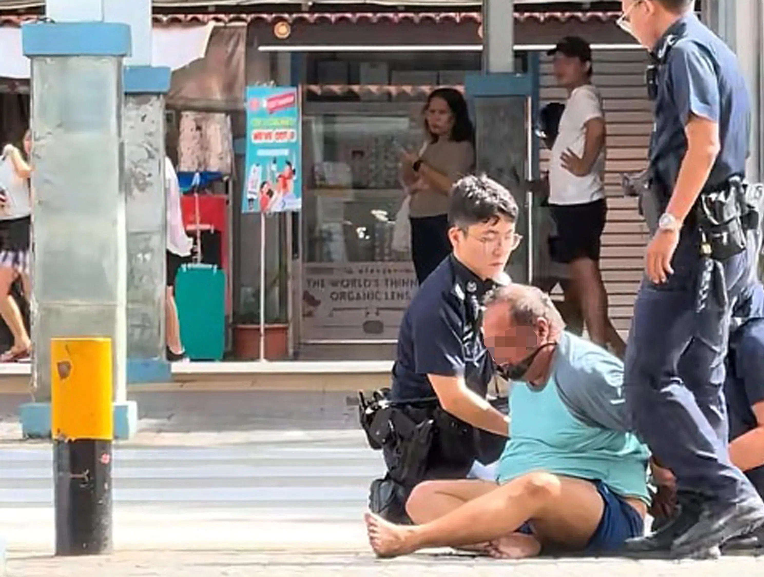 第三名警员和警车到场后，现场警员将男子翻至坐姿，随后在警方带领下步行离开现场。（TikTok视频截图）