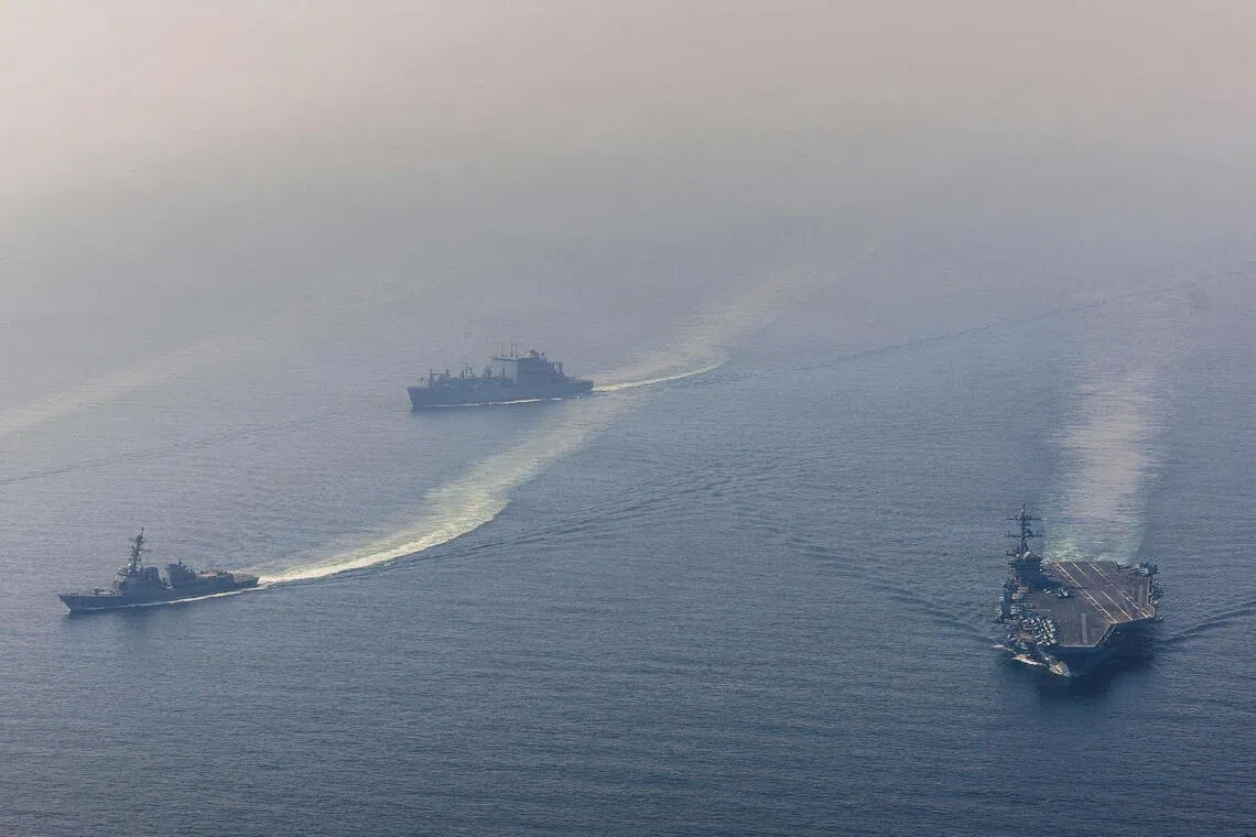 美国海军2月6日发布的照片显示，美军的亚伯拉罕·林肯号航母与导弹驱逐舰“小弗兰克·E·彼得森”号，以及干货船“卡尔·布拉希尔”号，在阿拉伯海共同航行。（法新社）