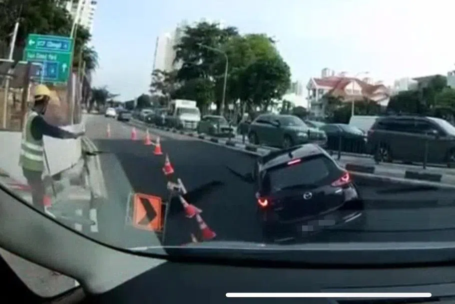 一辆轿车正左转驶入路口时，坠入路面毫无预警出现的坑洞。（视频截图）