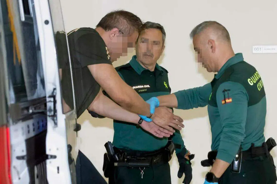 涉案的43岁新加坡籍男子，由两名警卫护送进入法庭。（互联网）