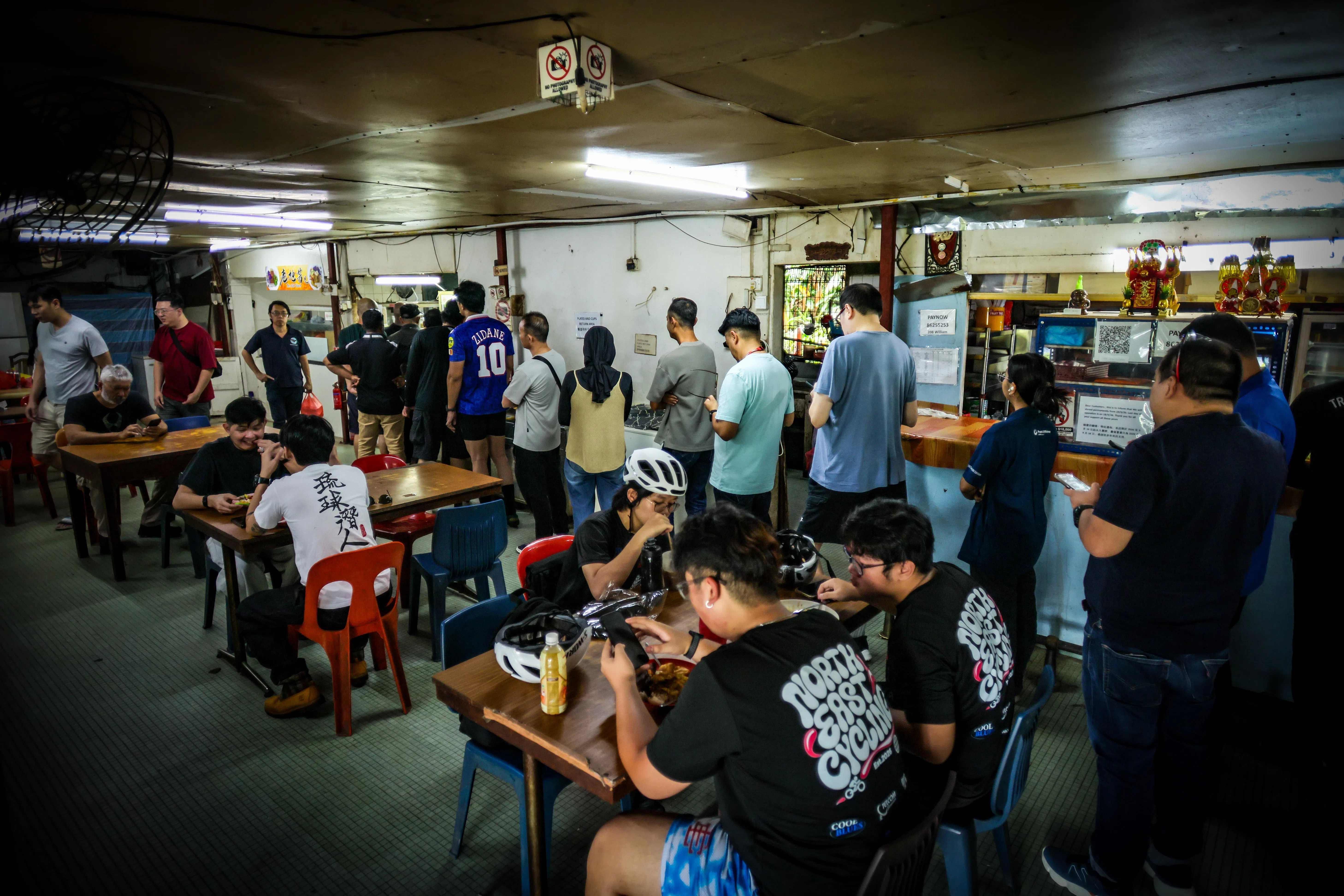 随着附近上班族午休时间来临，食堂的摊位前都排起长龙。（张俊杰摄）