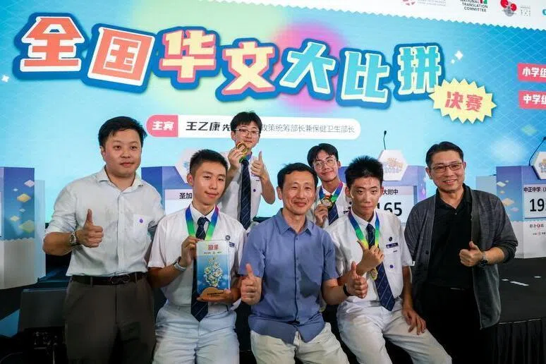 华文大比拼中学组冠军海星中学团队与社会政策统筹部长兼保健卫生部长王乙康合影。前排左起为海星华文部主任施伟良、参赛者张柏文、颁奖嘉宾王乙康、参赛者张耀博、校长白永成；后排为参赛学生吴冠亨（左）与刘明鑫（右）。