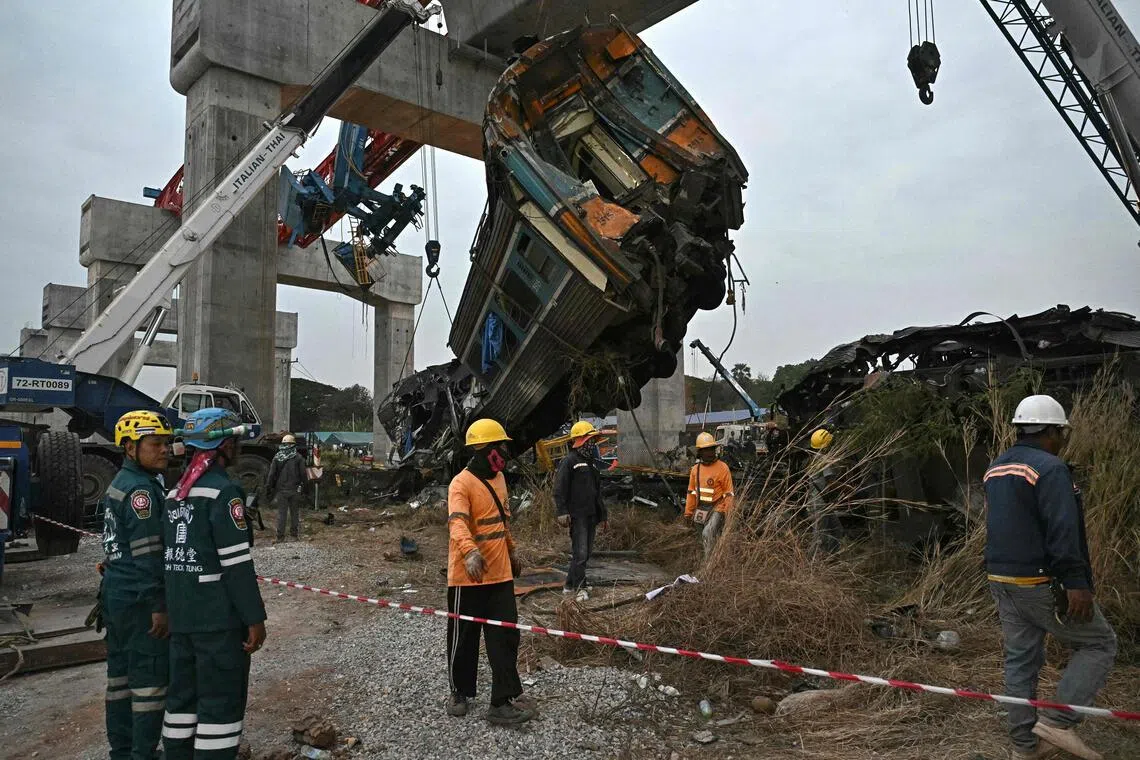 在泰国呵叻府高铁工地事故现场，救援队星期四（1月15日）将被倒塌的起重机砸毁的列车车厢吊离轨道。（法新社）