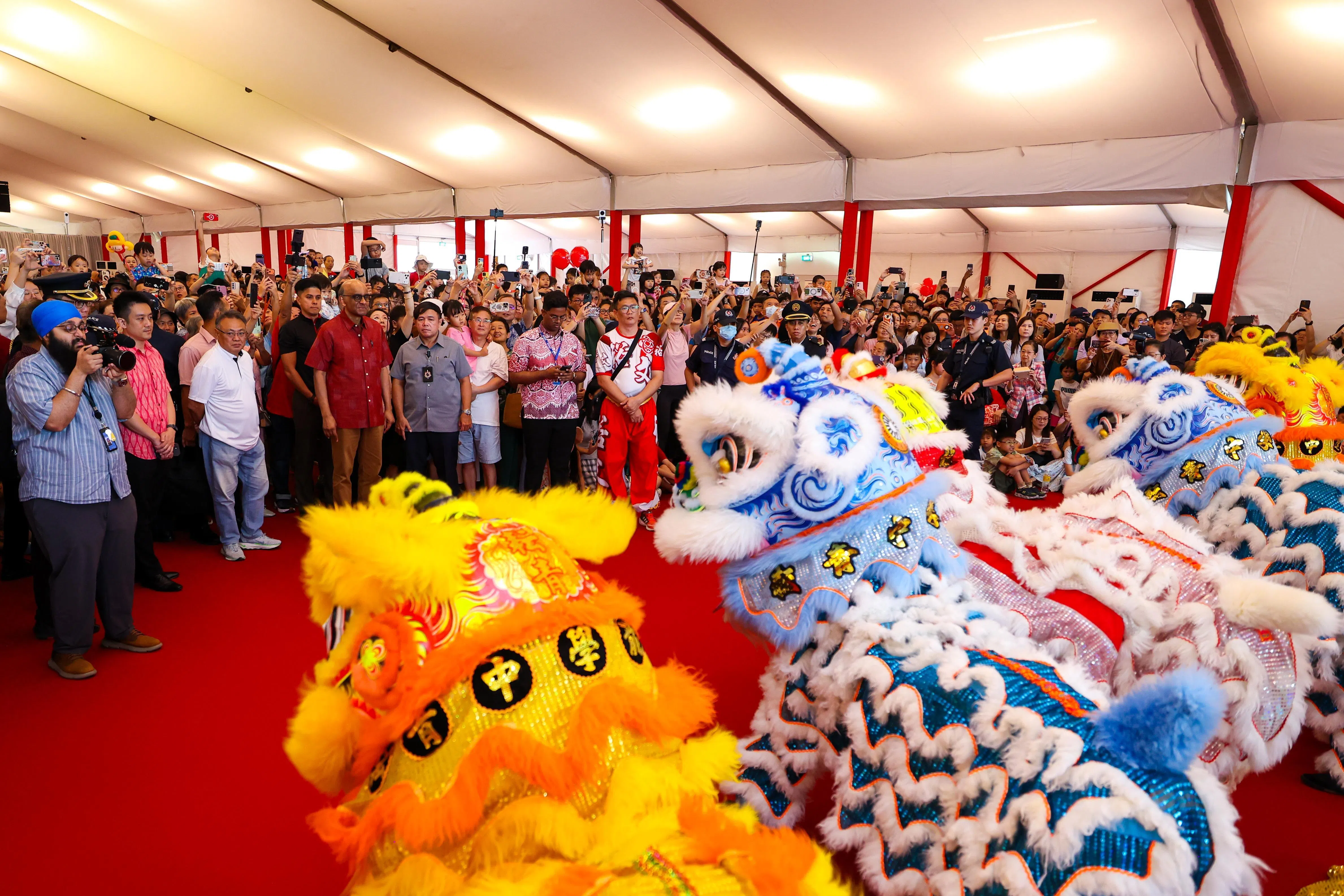 开放日安排了丰富多彩的活动和表演，图为尚达曼总统（前排中间深红衣）与公众一同观看舞狮表演。（林明顺摄）
