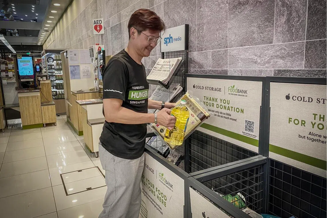 王建钛每周会开着车，到本地各大商场和超市的食物银行募捐箱收货。（新加坡食物银行提供）