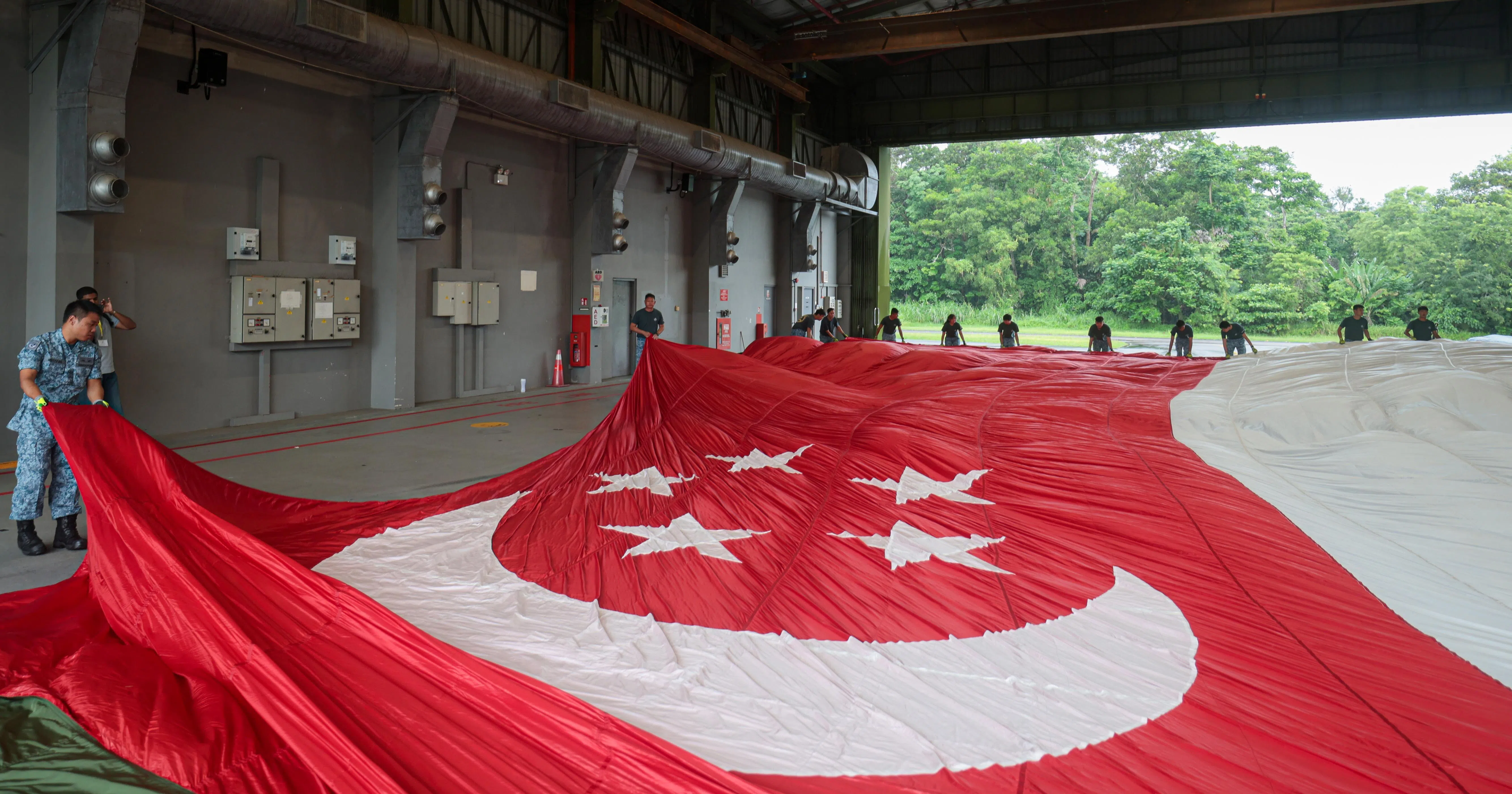 巨型国旗长30米，高20米，重约700磅（约317公斤），加上镇重物和钢索将重约3000磅（约1360公斤）。每周的彩排须动员多达90名人员参与准备工作，包括处理后备国旗。（李冠卫摄）