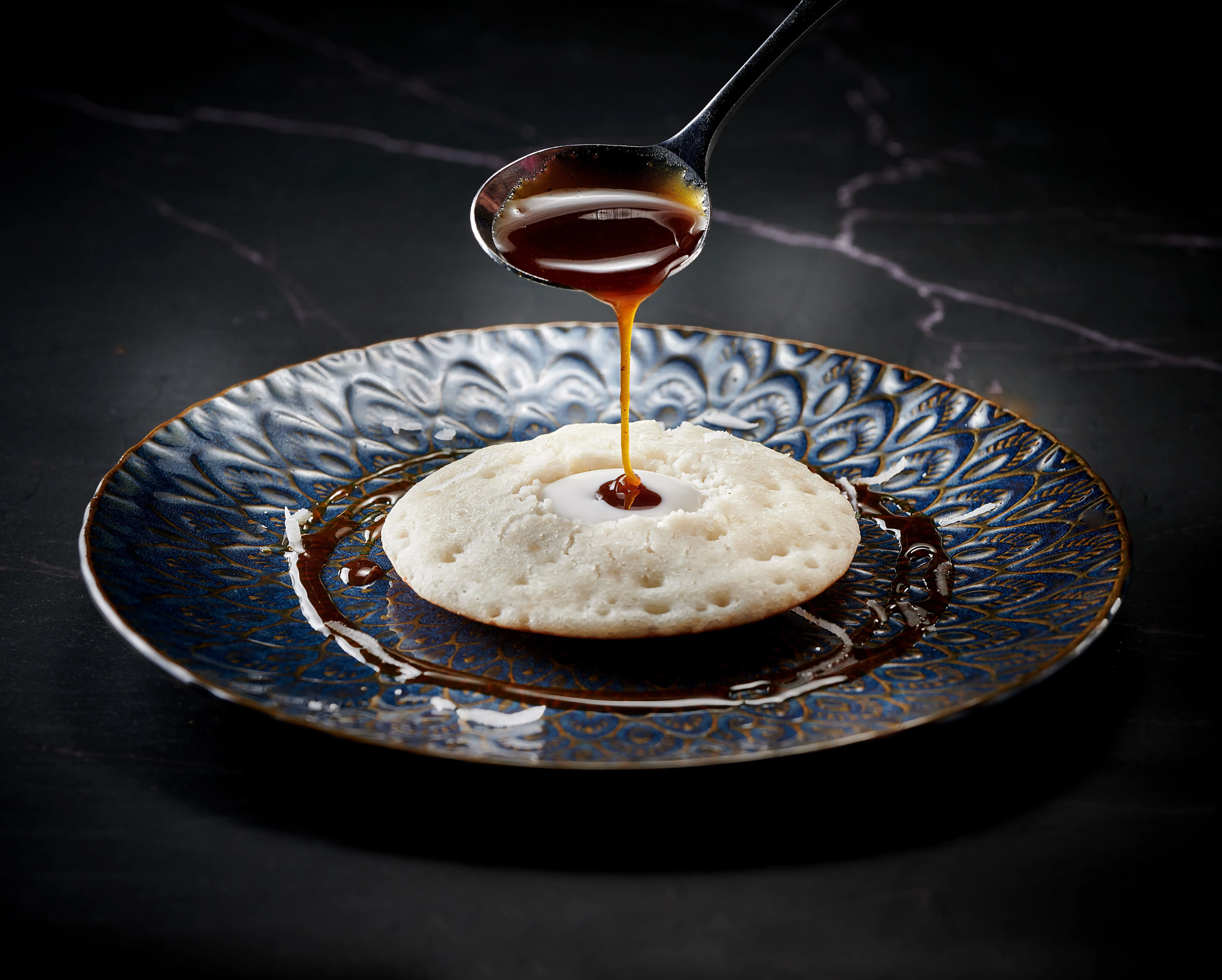 用发酵米和椰奶制成的阿榜appam，搭配椰糖和椰奶享用。（餐馆提供）