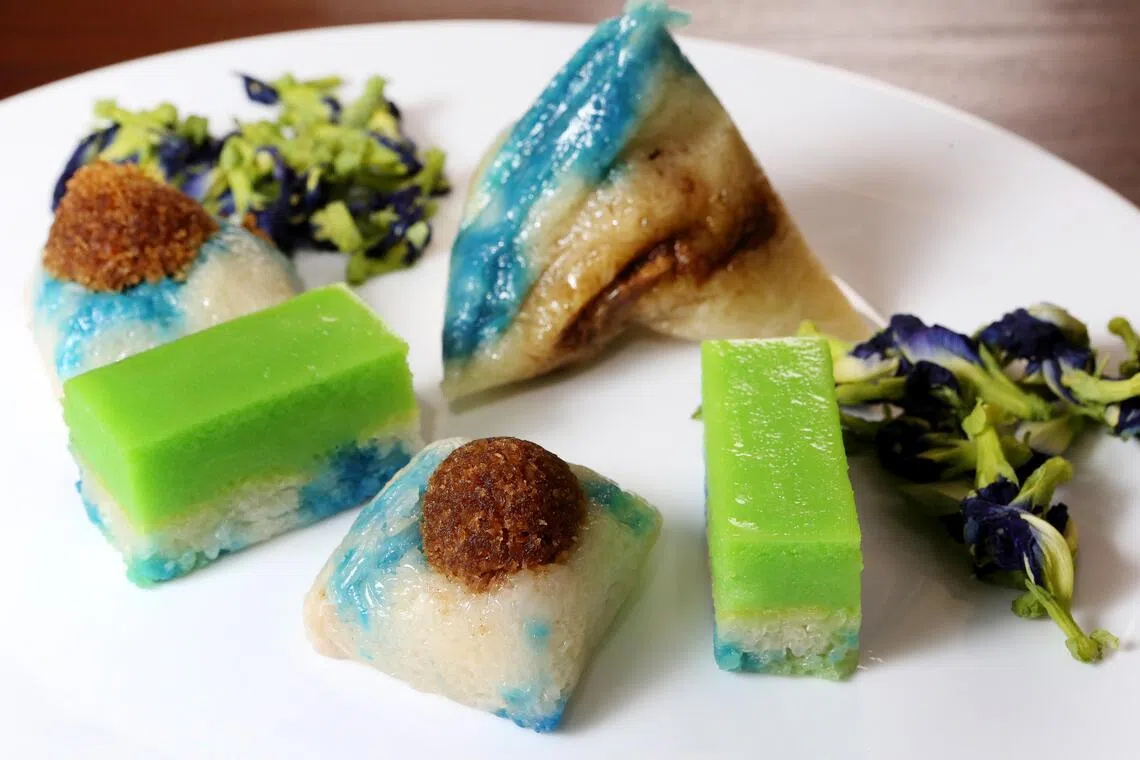 蝶豆花又称蓝花，是本地土生华人爱用的调色料，常见于传统娘惹糕点或粽子。图为“金珠肉粽”采用蝶豆花做成娘惹糕点和粽子。（龙国雄摄）