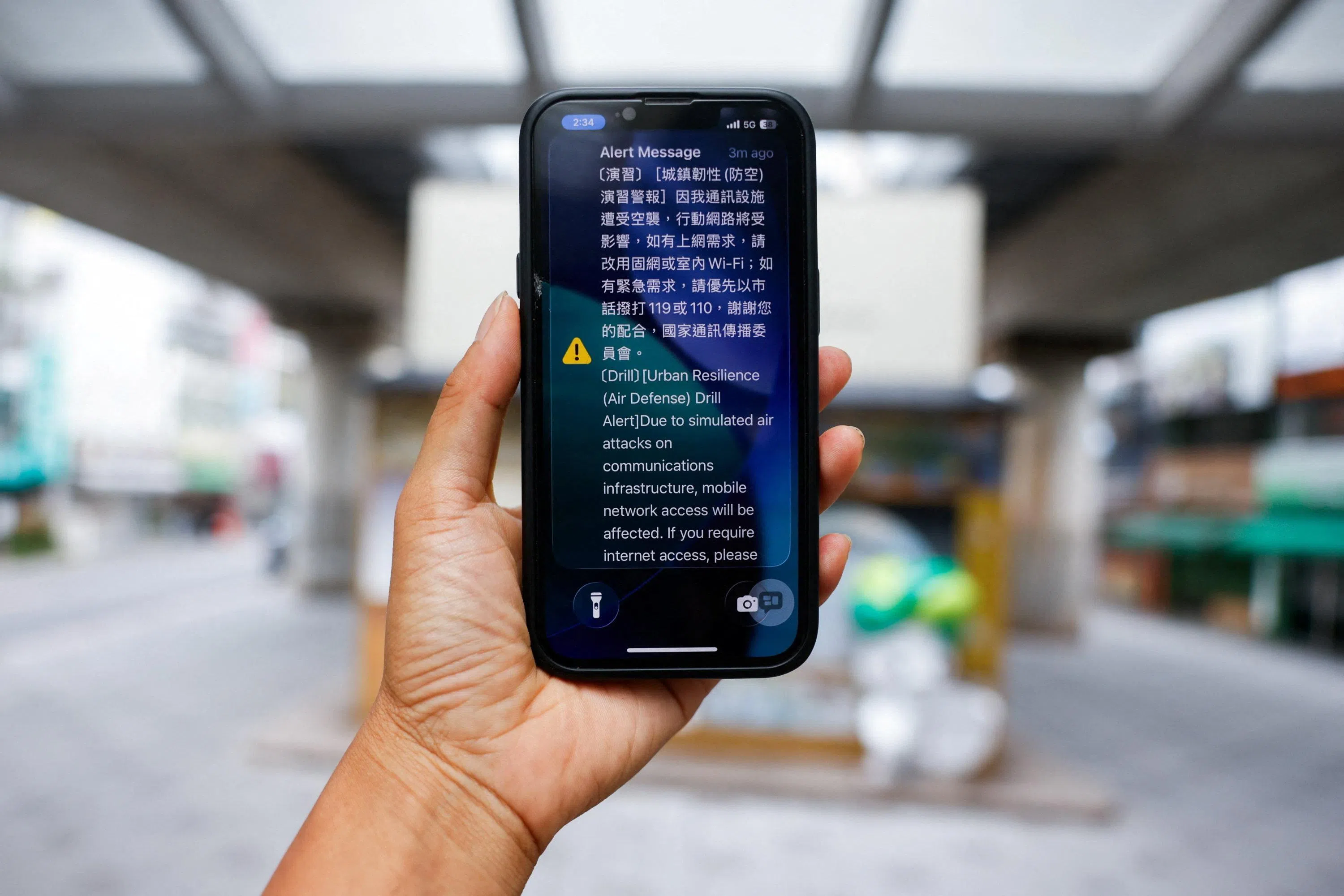 网络降速演练期间，一名台北民众收到移动通讯受影响的短信提醒。（路透社）
