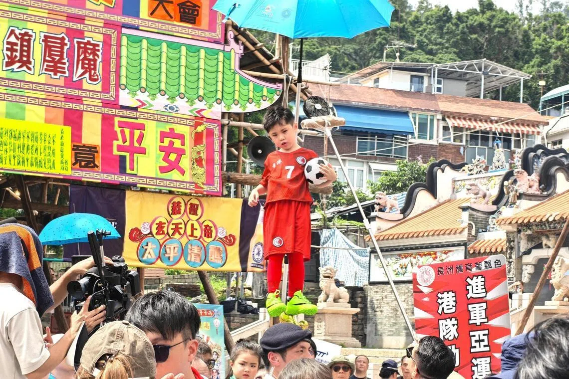 小朋友扮演足球员，打出“港队劲，进军亚运”的口号。（陈爱薇摄）
