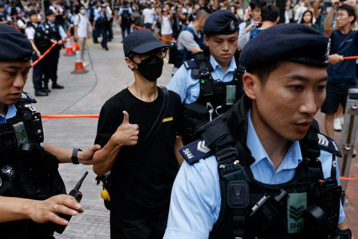 警方拘捕一名身穿黑衣的男子。（路透社）
