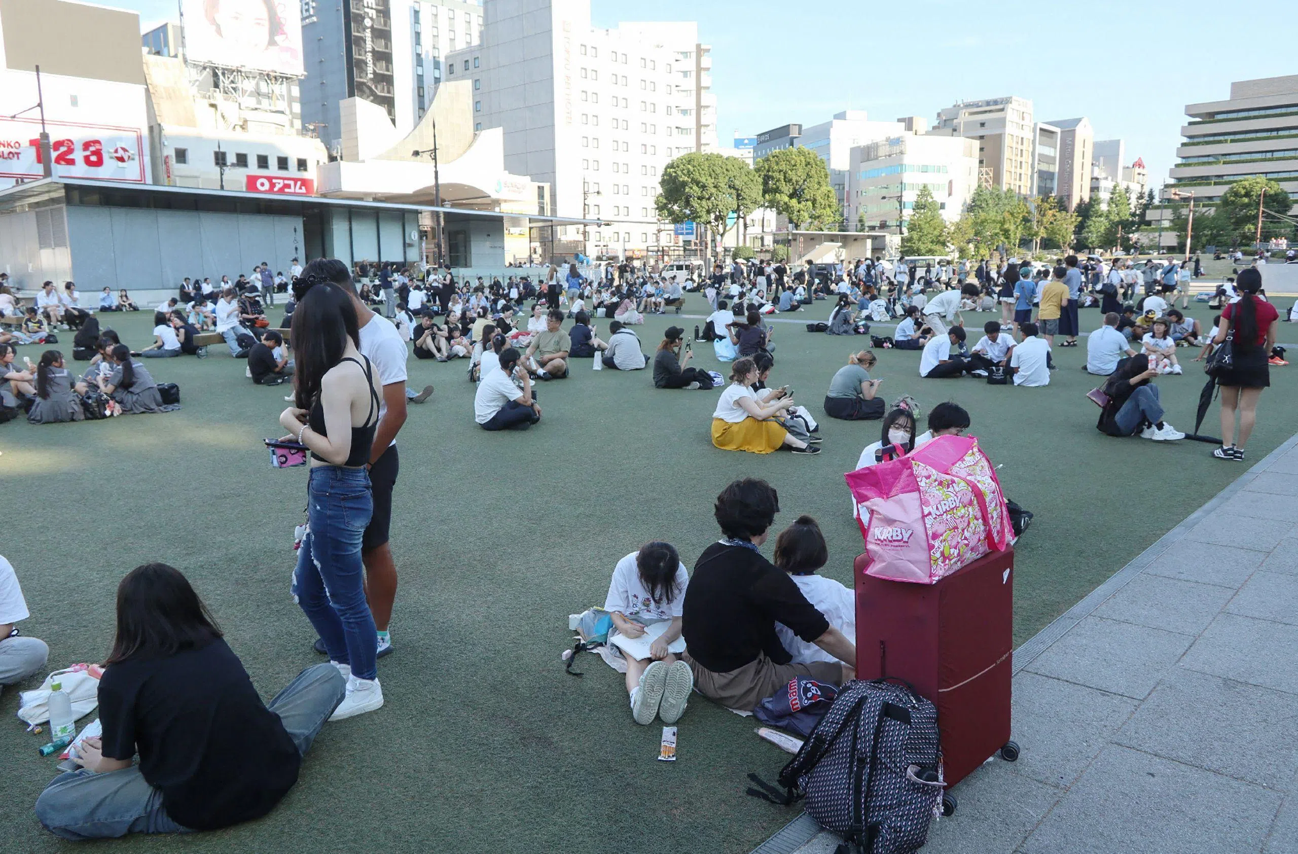 熊本市中央区的民众从大厦疏散后，在一处公园等候。（法新社）