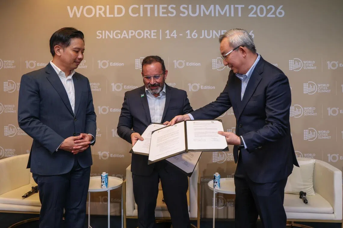国家发展部兼贸工部政务部长陈圣辉（左）在活动上见证国家公园局局长陈培育教授（右）与哥伦比亚卡利市高级可持续发展顾问毛里西奥（Mauricio Mira Pontón，中）交换谅解备忘录文本。（白艳琳摄）