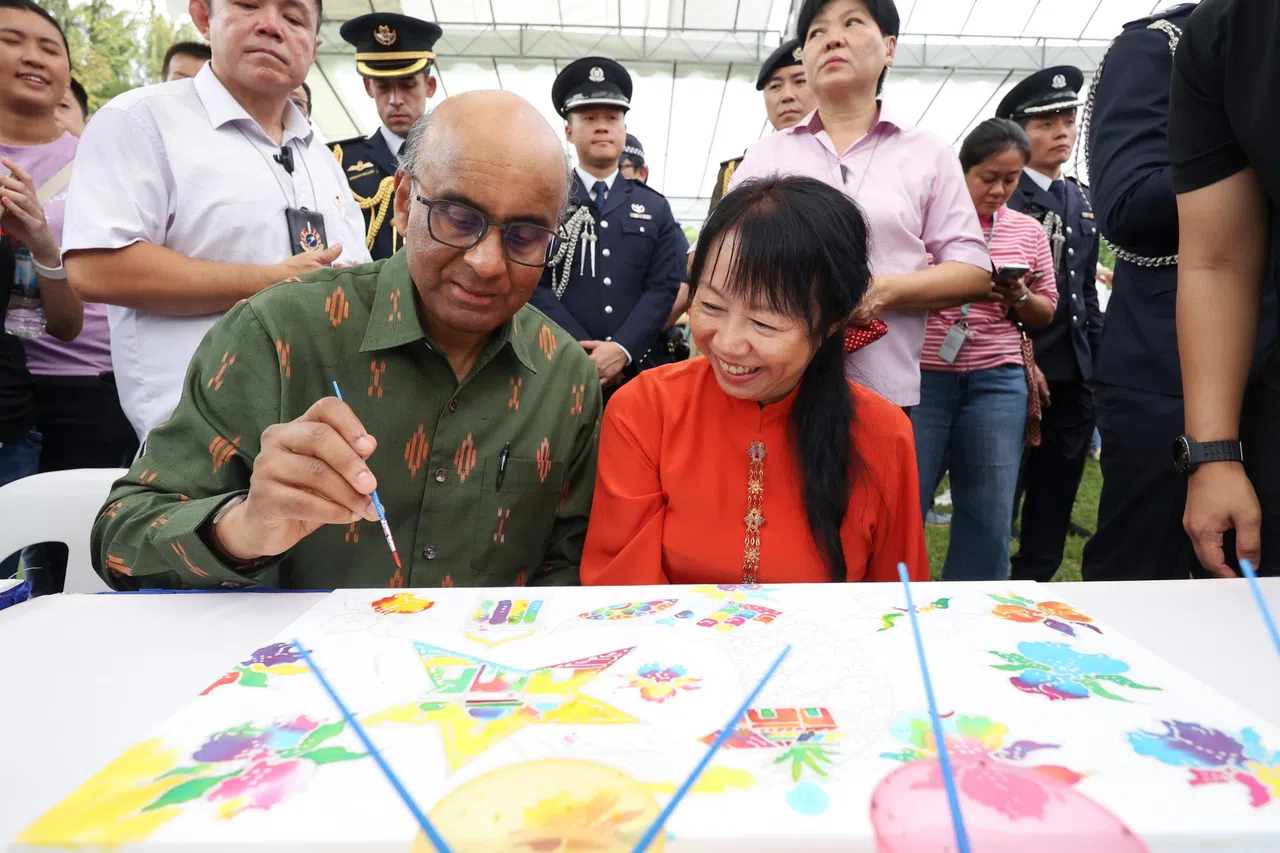 尚达曼总统（左）和夫人珍一藤木上午10点多参加总统府开放日，在职总俱乐部开办的峇迪绘画摊位尝试涂色活动，随后也与现场员工和访客互动。（数码发展及新闻部提供）