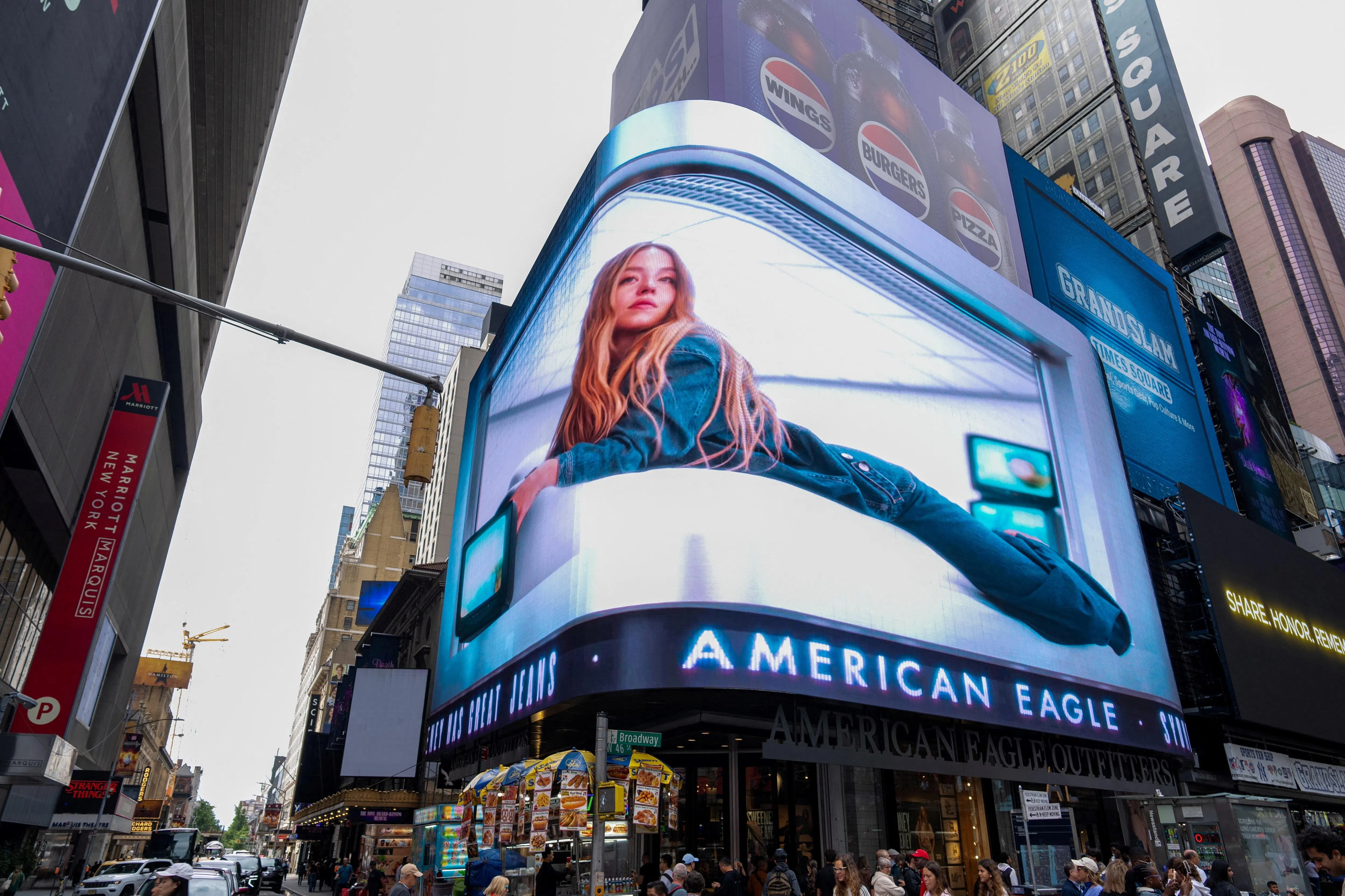 图为American Eagle Outfitters在美国纽约市电子广告牌上播放的悉尼·斯威尼广告。斯威尼已让品牌的牛仔服饰销售一空，流量实现同比两位数增长，同时也提升了品牌知名度和参与度。斯威尼的夹克，以及她的定制款牛仔裤更是在一天内售罄。（路透社）