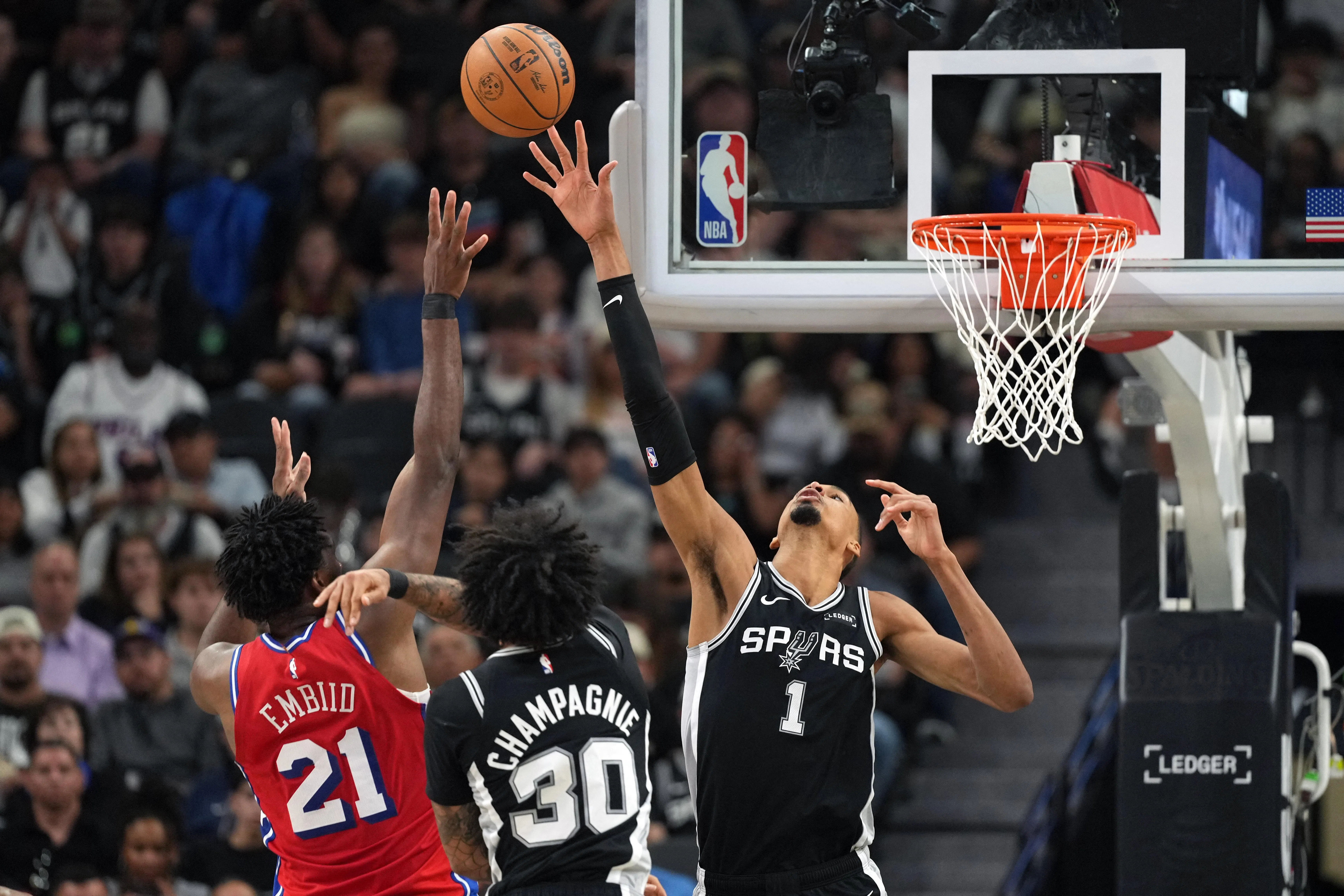 文班亚马（黑衣1号）在选秀时几乎没有模板可对比，是NBA史上“独一档的存在”。在联盟征战仅三个赛季后，他就成为攻防两端最令对手头疼的存在，就连身高2米13的中锋恩比德（左）在他面前都难以出手。（路透社）