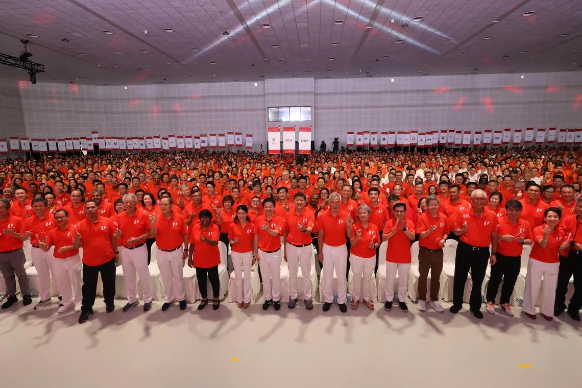 五一劳动节集会星期四在白沙乐怡度假村举行。虽然是2025年全国大选竞选期，到场的劳资政三方代表，包括人民行动党的候选人，都穿上橙红色的职总马球衫。出席者包括（前排左起）前职总秘书长林瑞生和陈振声、国会议长谢健平、前工运官委议员阿都沙曼、国务资政兼国家安全统筹部长张志贤、人力部长兼贸工部第二部长陈诗龙医生、职总会长丹娜乐芝米、黄循财总理夫人吕子蕊、黄总理、职总秘书长黄志明、国务资政李显龙、李资政夫人何晶、副总理王瑞杰、新加坡全国雇主联合会会长陈启德、荣誉国务资政吴作栋、职总副会长林志康、永续发展与环境部长傅海燕，以及前职总秘书长林文兴。（邝启聪摄）