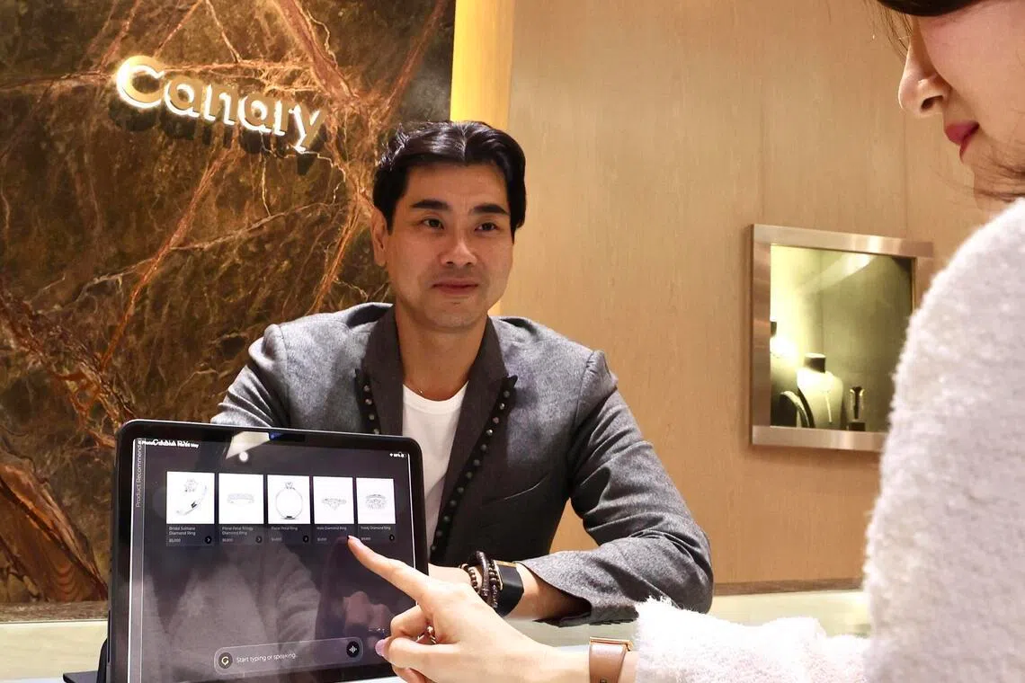 精品珠宝商The Canary Diamond利用AI平台提升顾客购物体验，并帮助员工提升销售技能。总经理林君铭使用平板电脑的智能推荐，向顾客展示珠宝产品。（邬福梁摄）